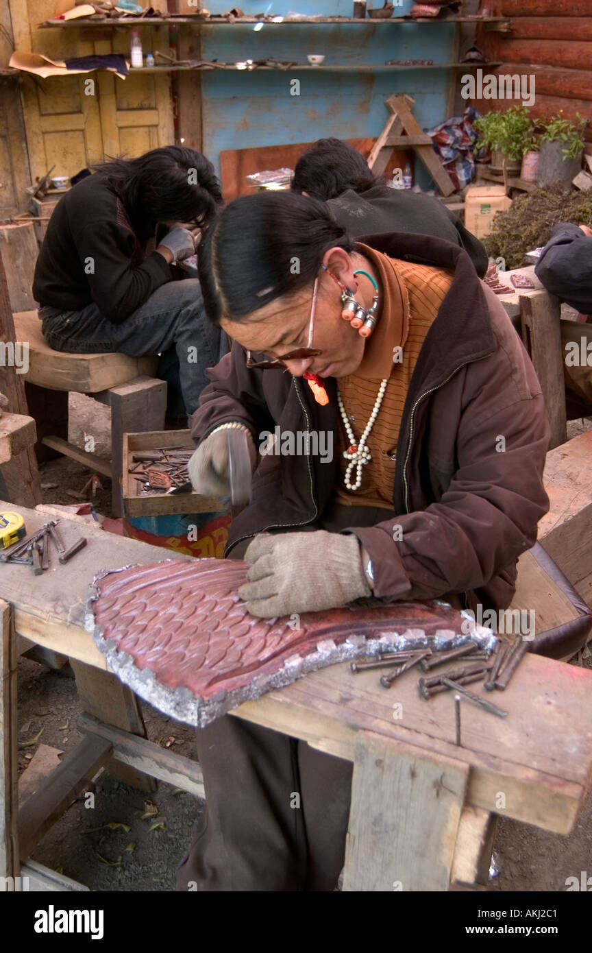 Metal worker makes repousse peice for the Buddhist Monastery of Tagong Lhagang Kham Sichuan Province China Tibet  Stock Photo