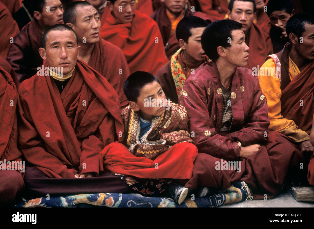 Nyingma monks watch the Buddhist Cham Dances Katok Dorjeden Monastery Kham E Tibet Sichuan Province China Stock Photo