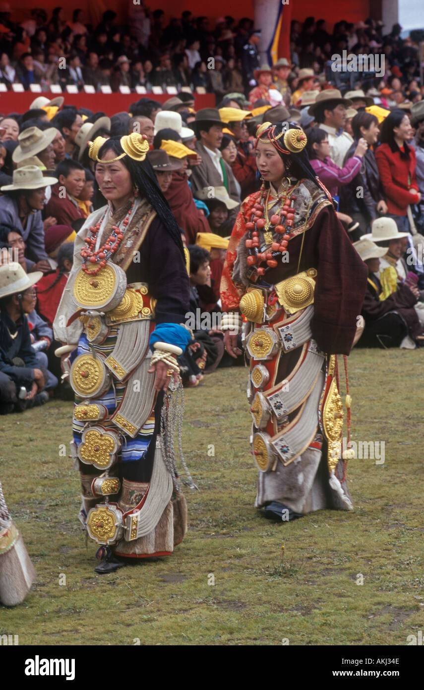 Female Khampas wear gold hair pieces gau boxes zee stones coral at the Litang Horse Festival Sichuan Province China Stock Photo