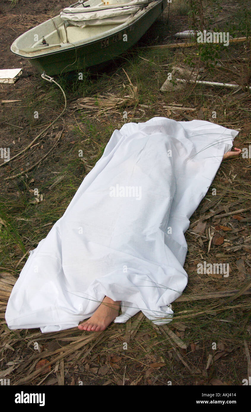 Foot of Caucasian Female Dead Body Protruding from Under White Sheet in South Carolina Swamp USA, Crime Scene Stock Photo