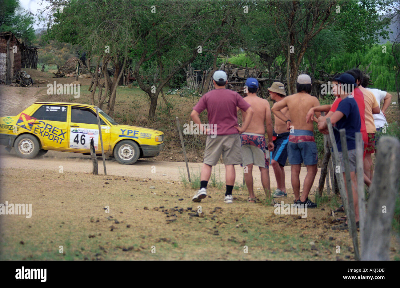 A group of people watches a car racing during a national rally ...