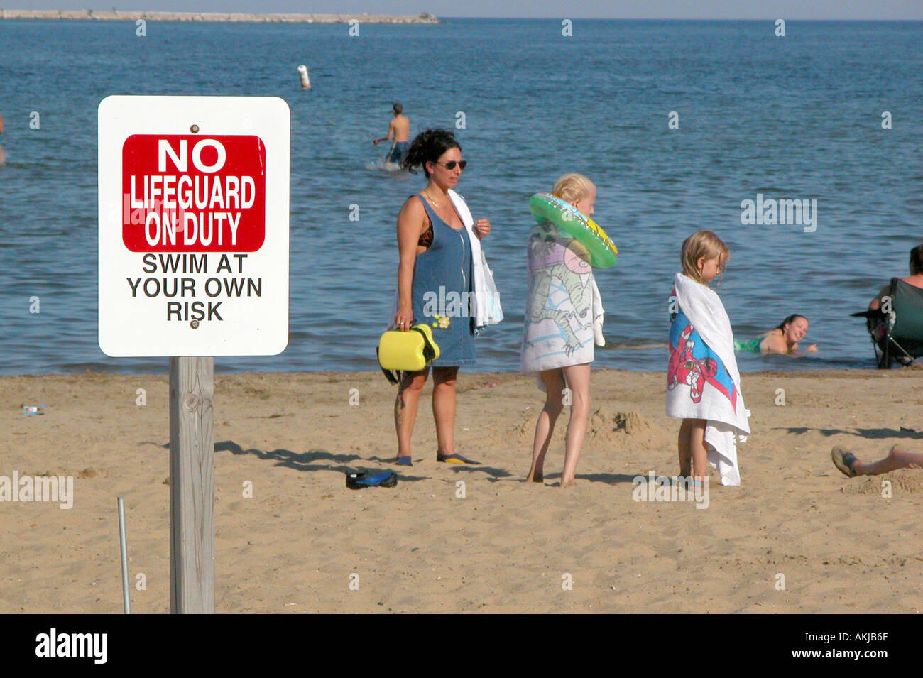 Sign on public beach states No life guard on duty swim at own risk Stock Photo