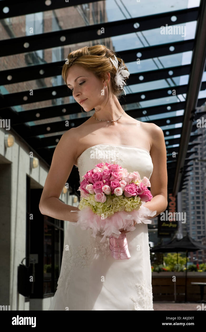 a beautiful bride in a white wedding dress holding her flower bouquet ...