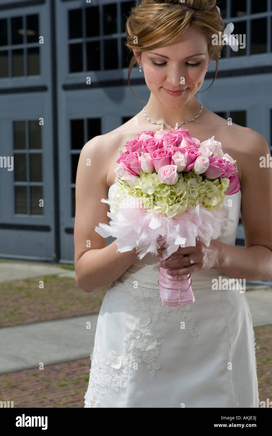 a beautiful bride in a white wedding dress holding her flower bouquet ...