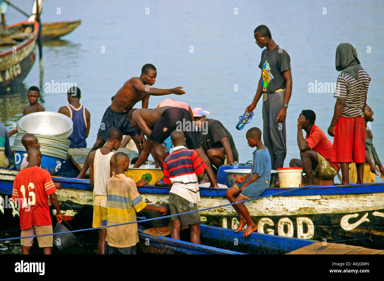 Fishermen bring in the catch in traditional fishing boats in Elmina Ghana Stock Photo