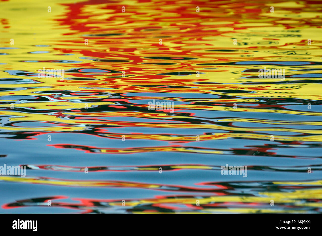 Ripples on still water reflecting red yellow and orange Stock Photo - Alamy