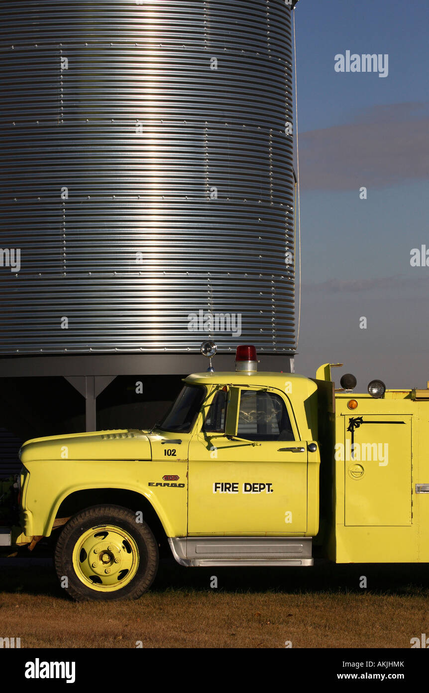 Old fire truck beside grain silo in rural Saskatchewan Stock Photo