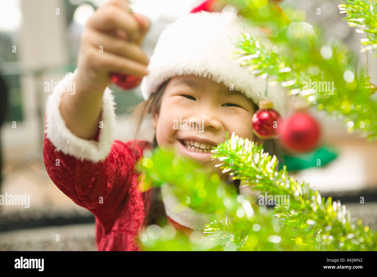 Happy girl decorating Christmas tree Stock Photo