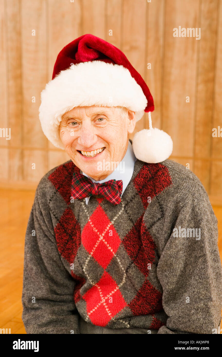 Portrait of elderly man wearing santa hat Stock Photo