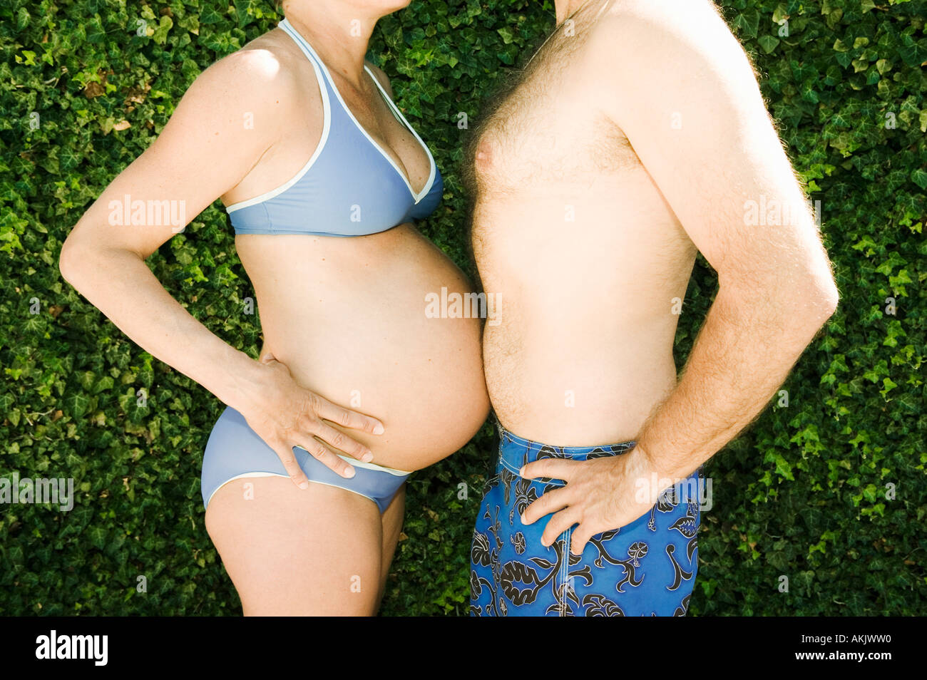 Man and pregnant woman touching bellies Stock Photo