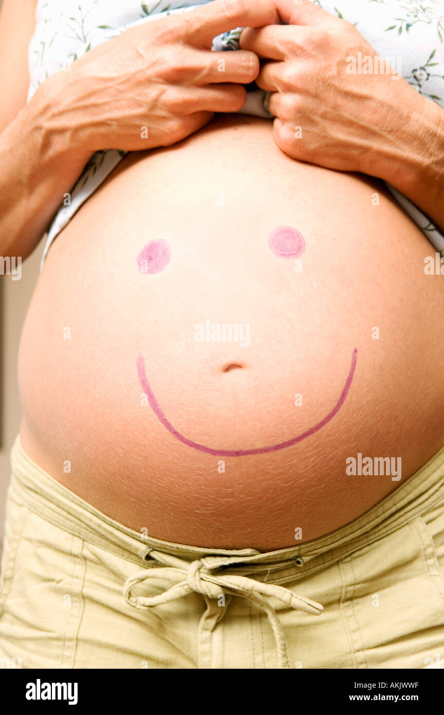 Closeup of pregnant belly with smiley face Stock Photo