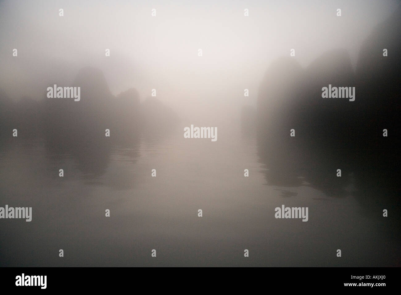Rocks and water through mist at dawn Stock Photo - Alamy