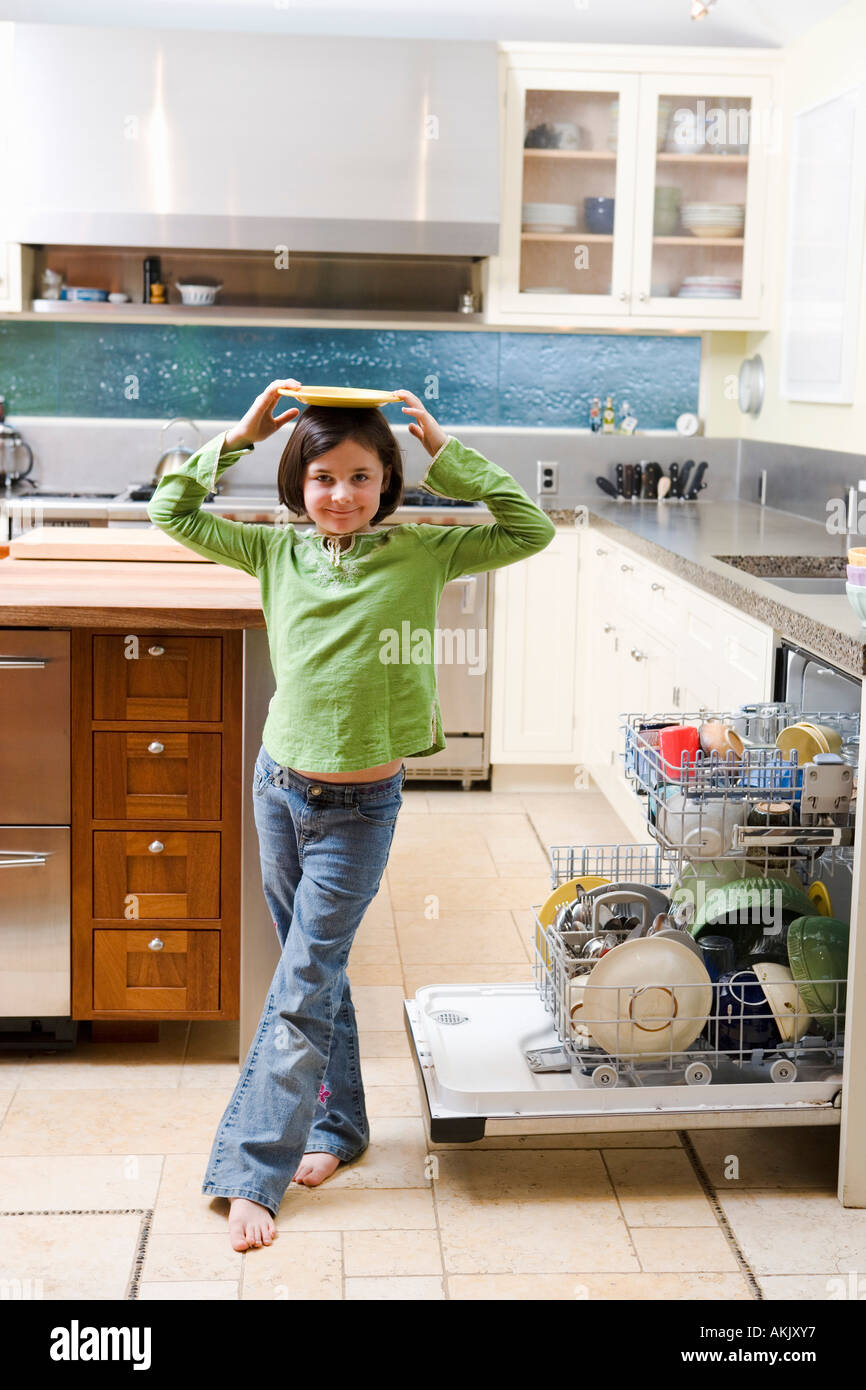 Girl balancing plate on head in kitchen Stock Photo Alamy