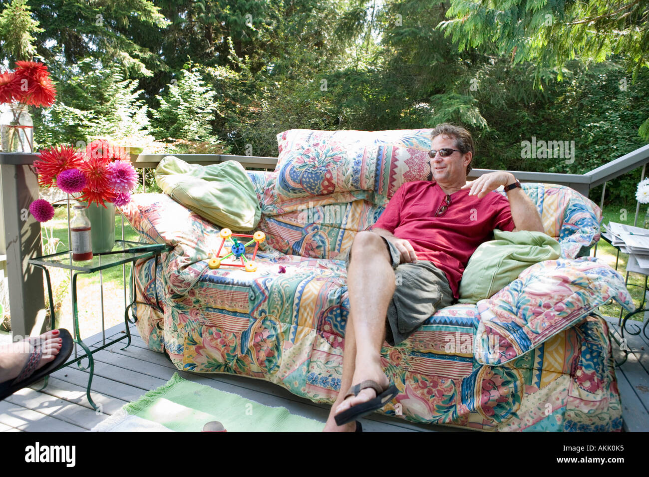 Man relaxing on couch on porch Stock Photo Alamy