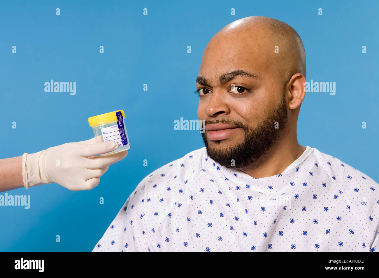 Male patient being handed sample container Stock Photo - Alamy