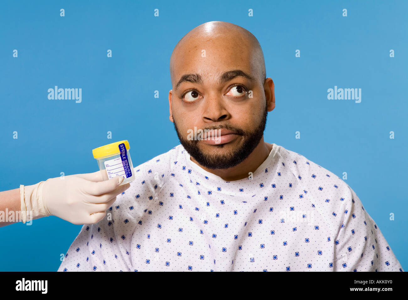 Male patient being handed sample container Stock Photo - Alamy