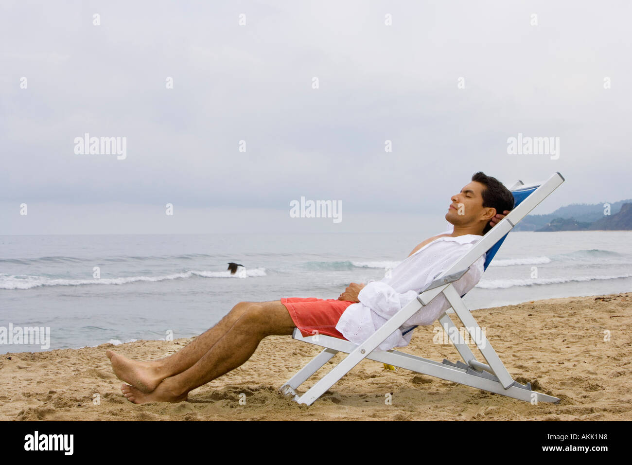 Man sleeping in chair at beach Stock Photo Alamy