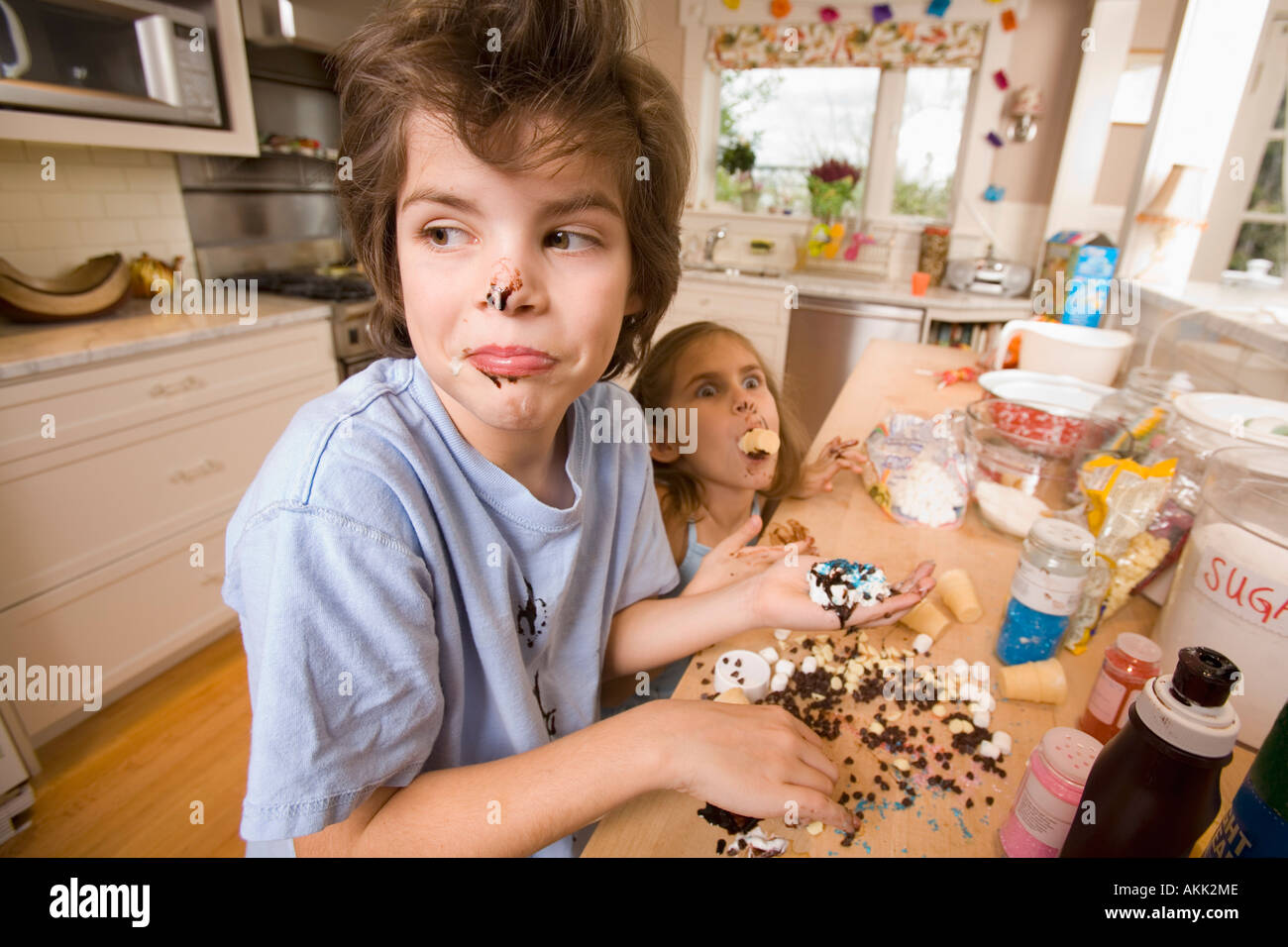 Brother and sister making mess in kitchen Stock Photo - Alamy