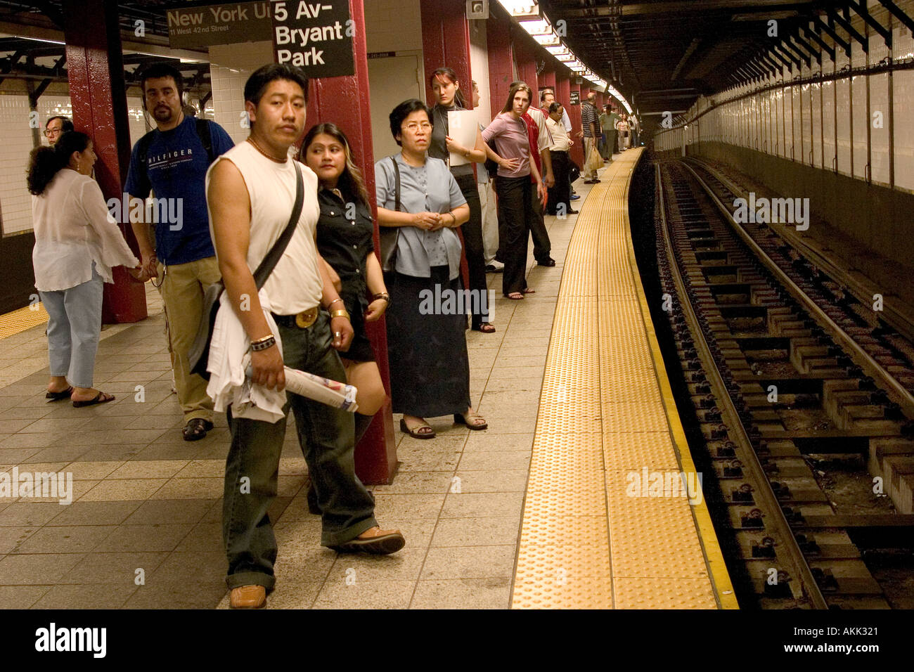 Transit riders waiting for the subway at the 42nd Street Station in NYC ...