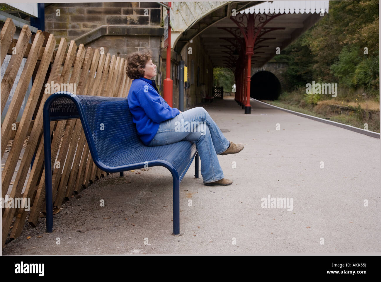 Woman waiting for a train at Cromford railway station Derbshire in the Peak District Stock Photo