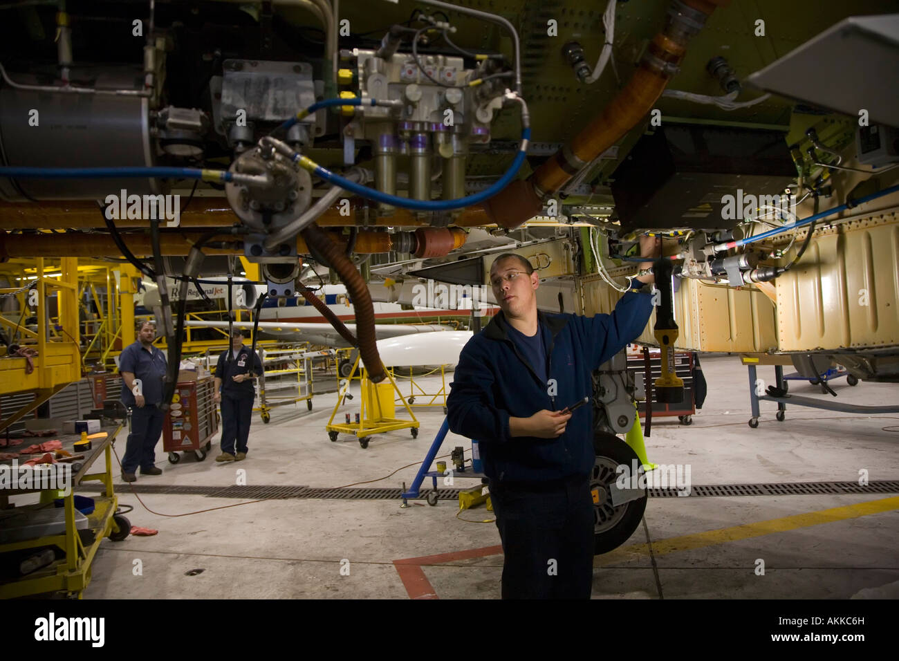 Workers do heavy maintenance on American Eagle Embraer jet airplanes at Sawyer International Airport Stock Photo