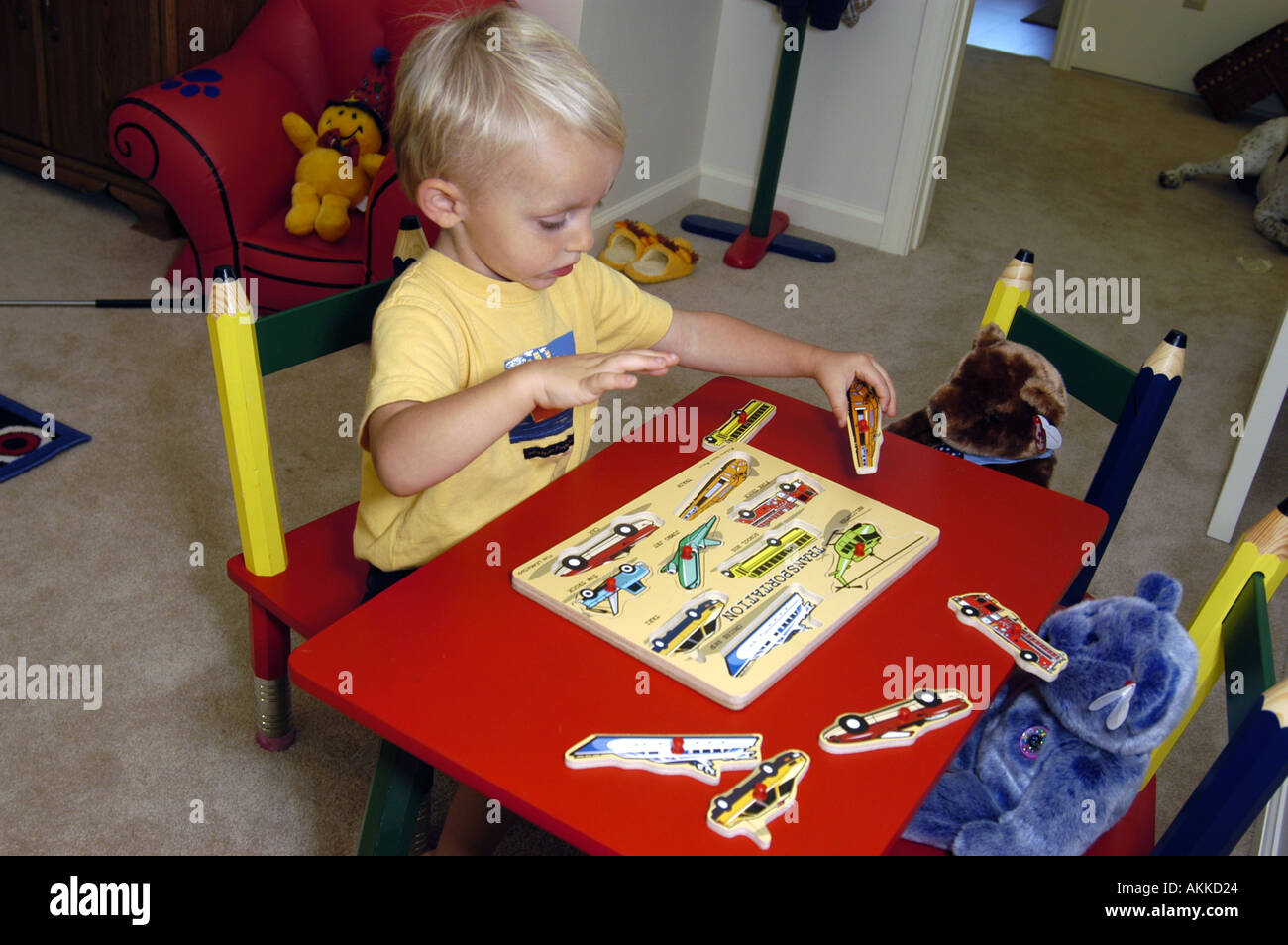 2 Year Old Boy Works With Wooden Puzzle In His Bedroom Stock