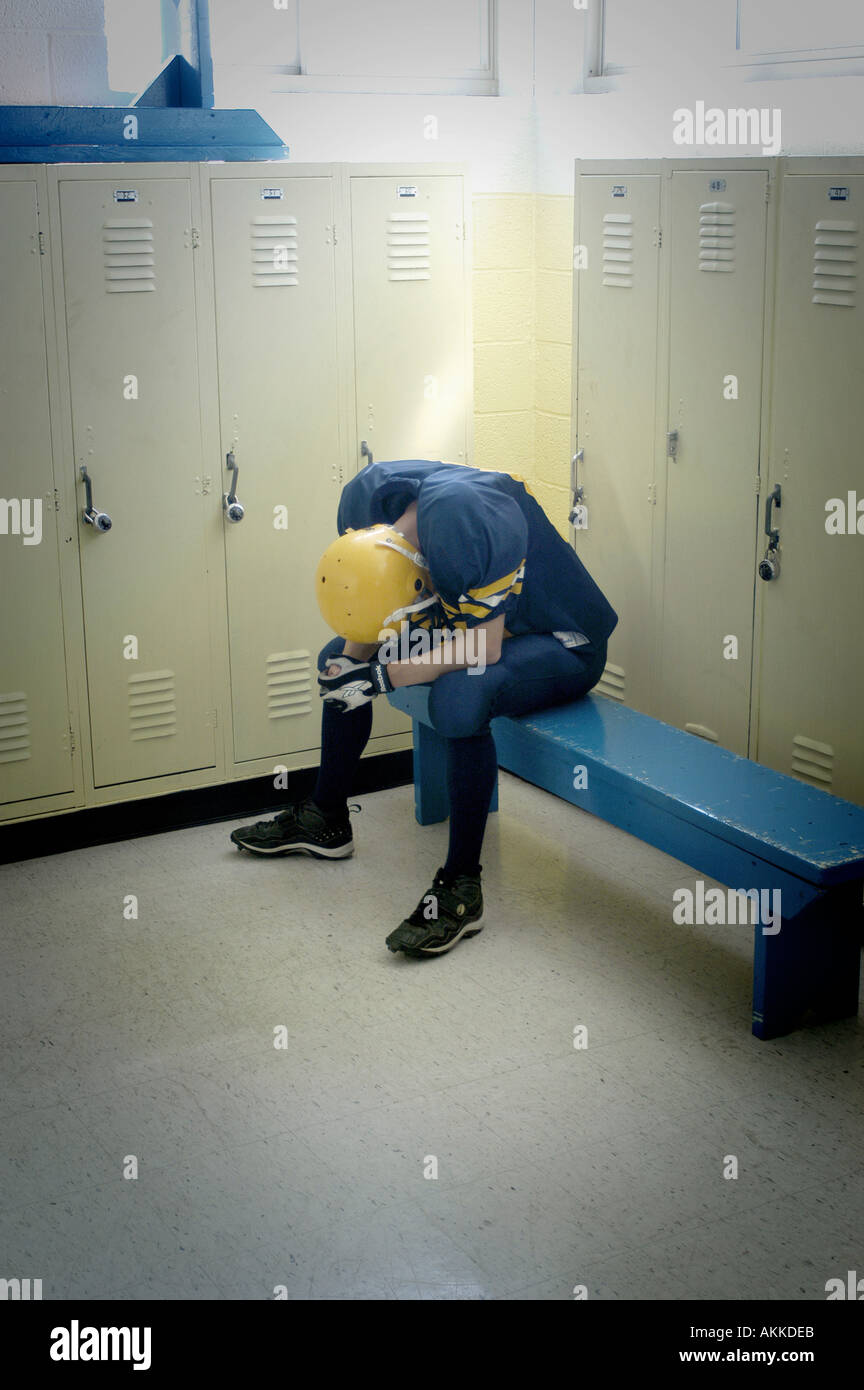 Depressed football player in locker room High School Football action Port Huron Michigan Stock Photo