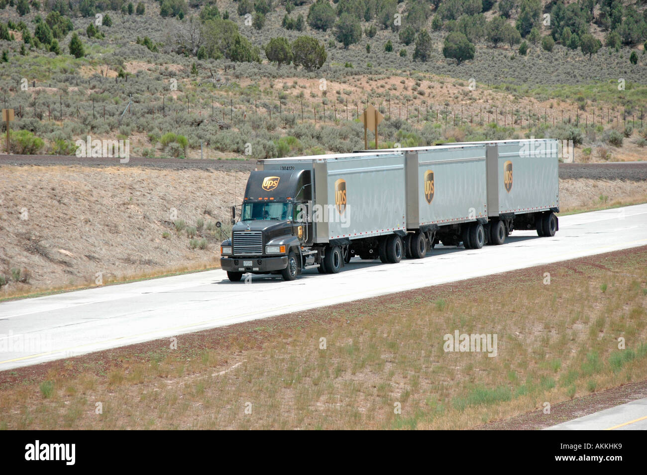 Commercial Trucks in highways roads freeways with cars with triple three 3  trailers in Colorado going at speed Stock Photo - Alamy