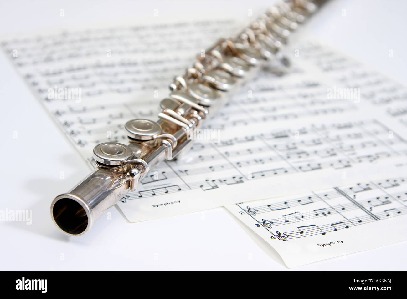 Flute laying on sheet of classical notes Stock Photo
