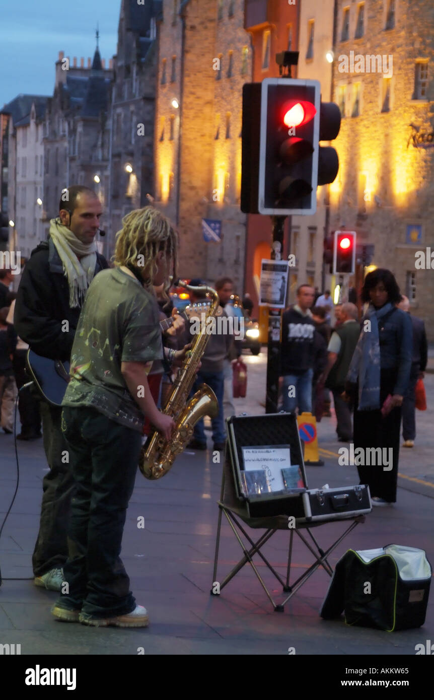 Edinburgh Festival Scotland Fringe female Sax player busking on sidewalk street kerbside Royal