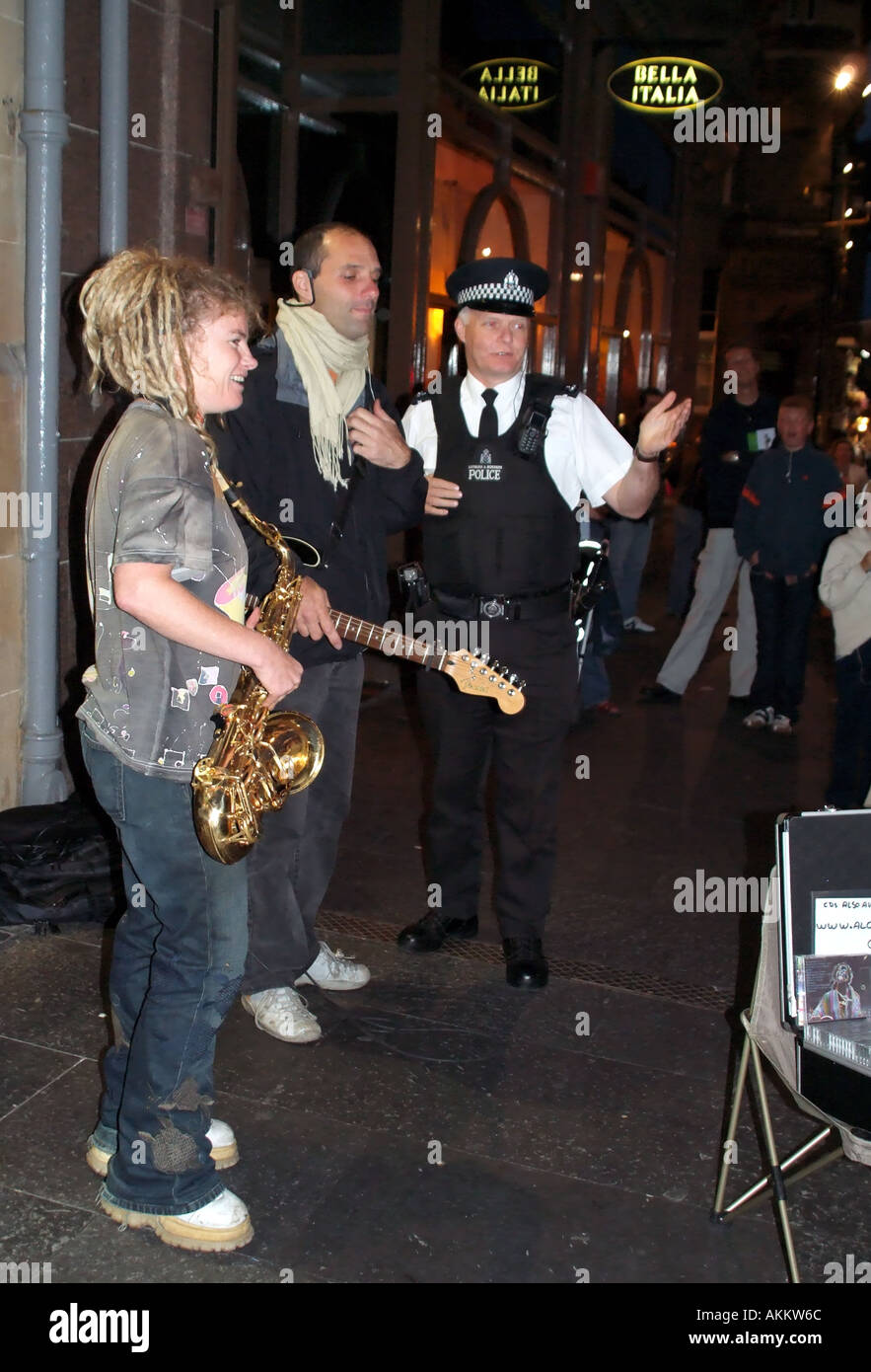 Edinburgh Festival Scotland Fringe female Sax player busking on sidewalk street kerbside police