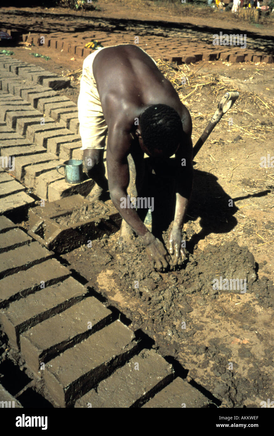 Black african man making adobe bricks for housing in Mozambique Africa Stock Photo