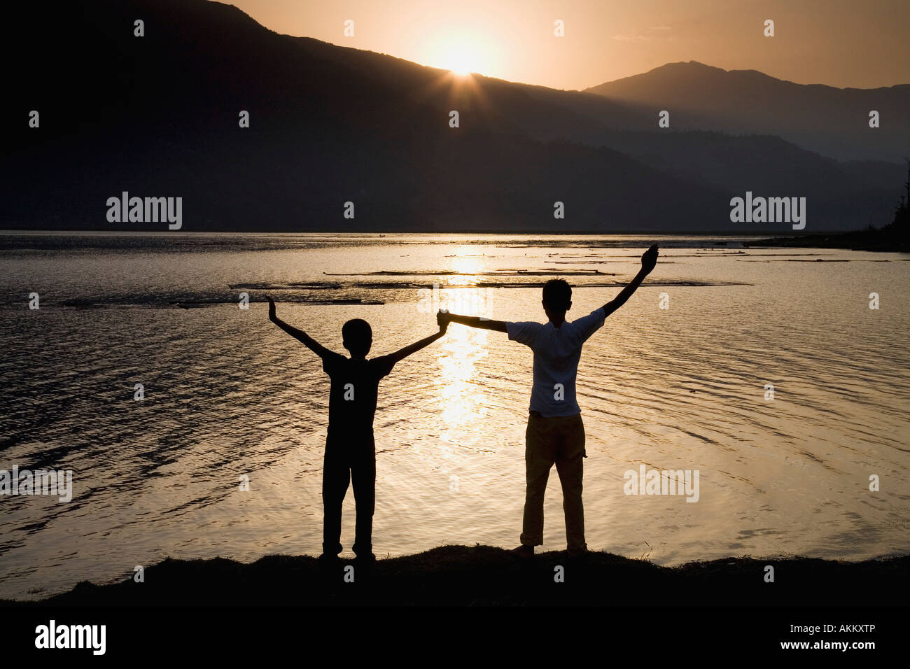 Children holding hands stretched up to the sky Stock Photo