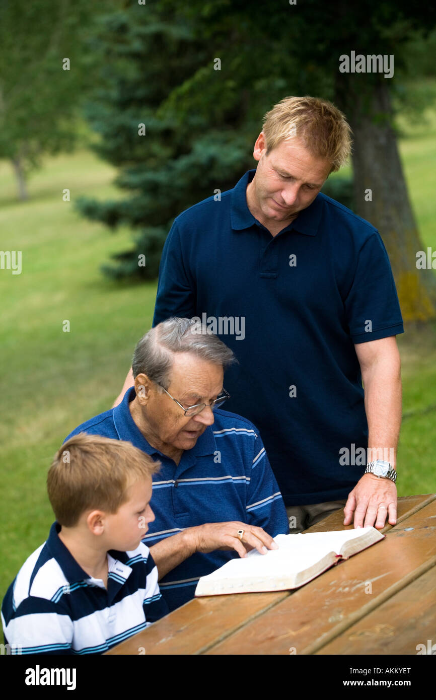 Three generations reading the Bible Stock Photo