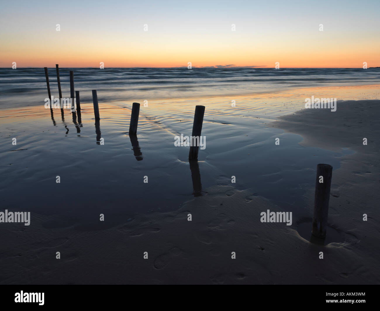 Canada Ontario Sauble Beach posts on sandy beach at sunset over Lake Huron Stock Photo