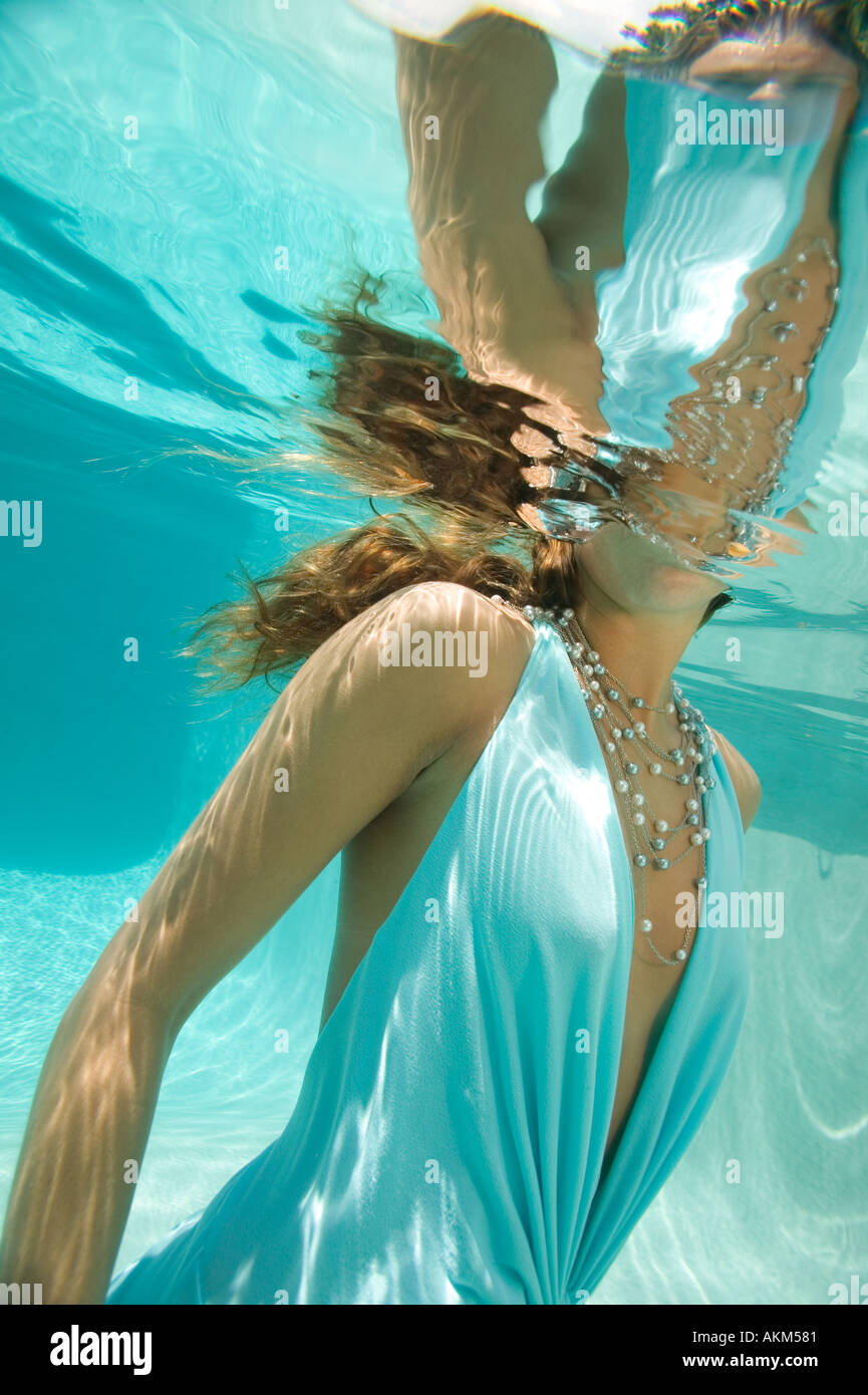 Woman in blue dress and silver necklace underwater Stock Photo