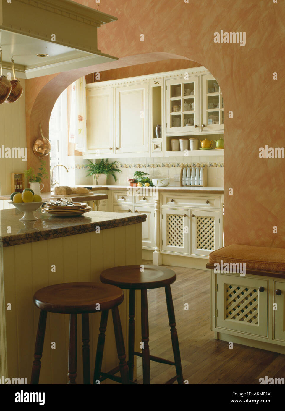 Stools at island unit in kitchen with rag rolled paint effect