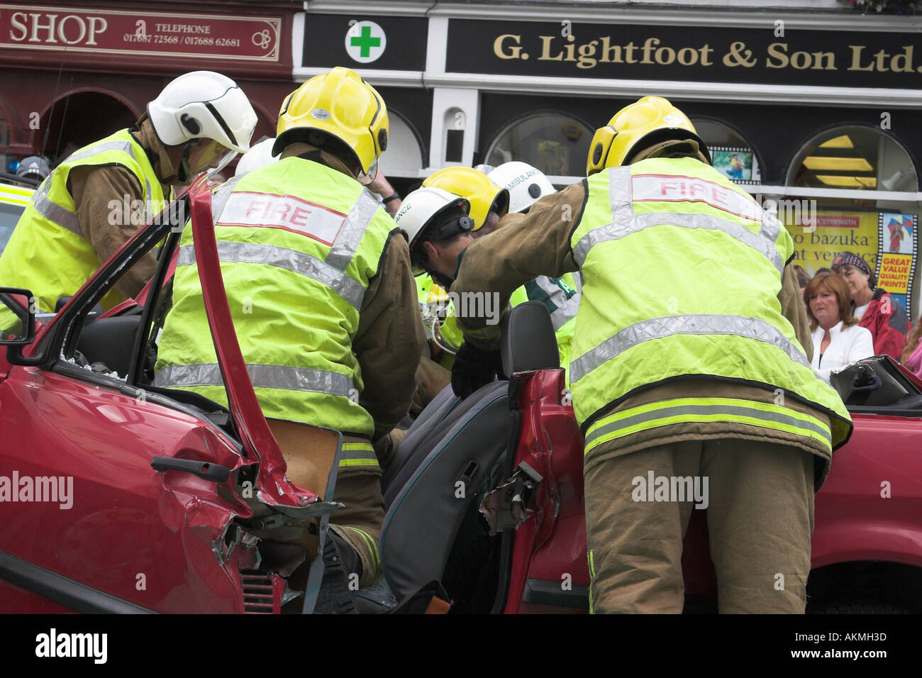 ambulance paramedic and firemen treat an injured driver in a car crash scenario training