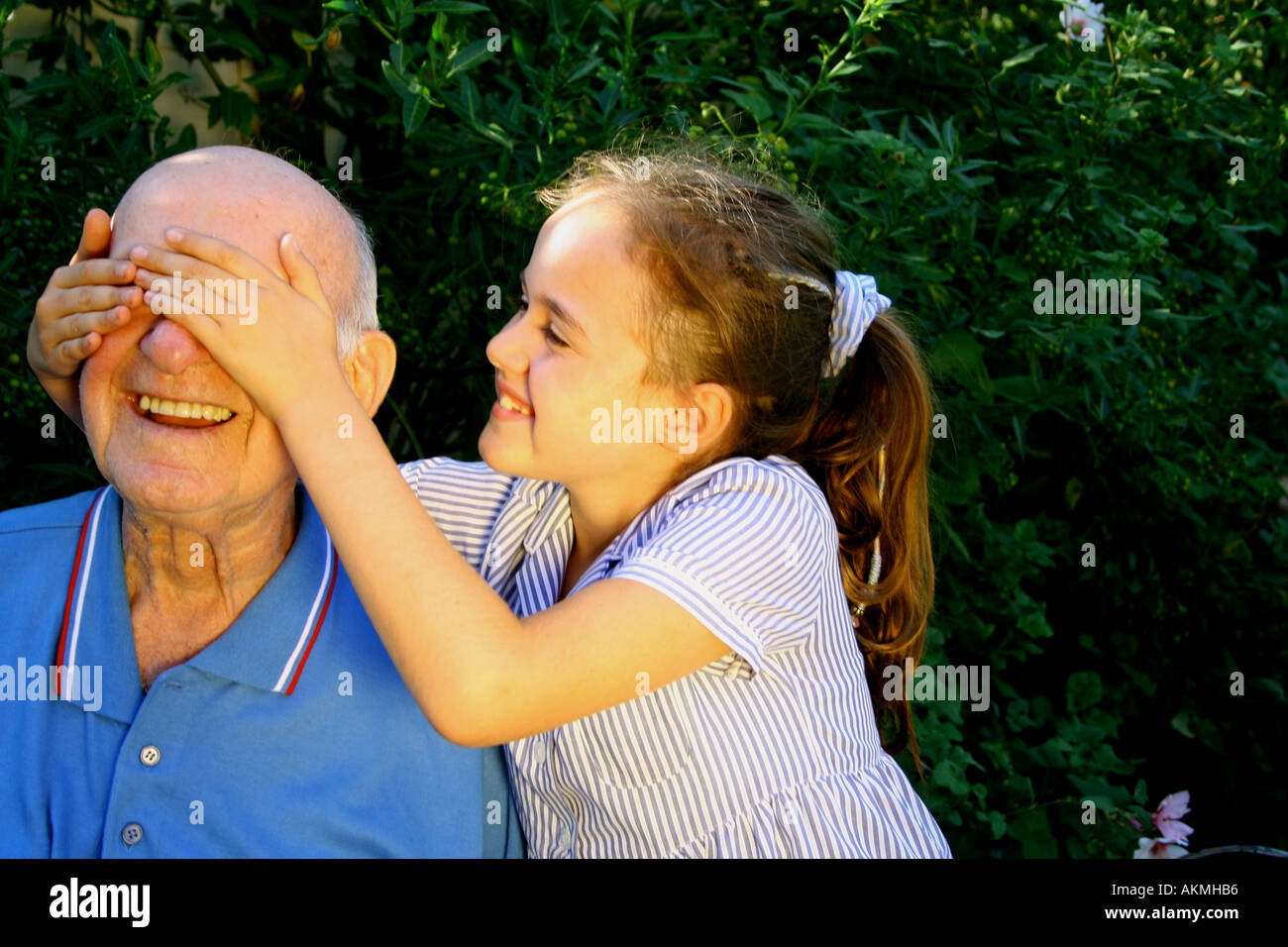 Guess Who Little girl surprises grandad who she adores Stock Photo