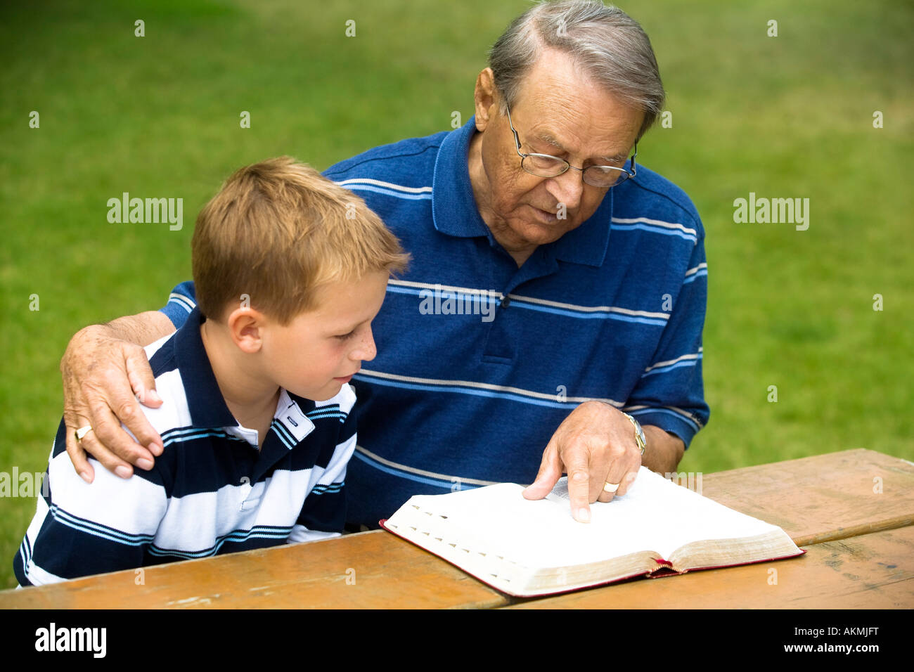 Grandfather and grandson reading the Bible Stock Photo
