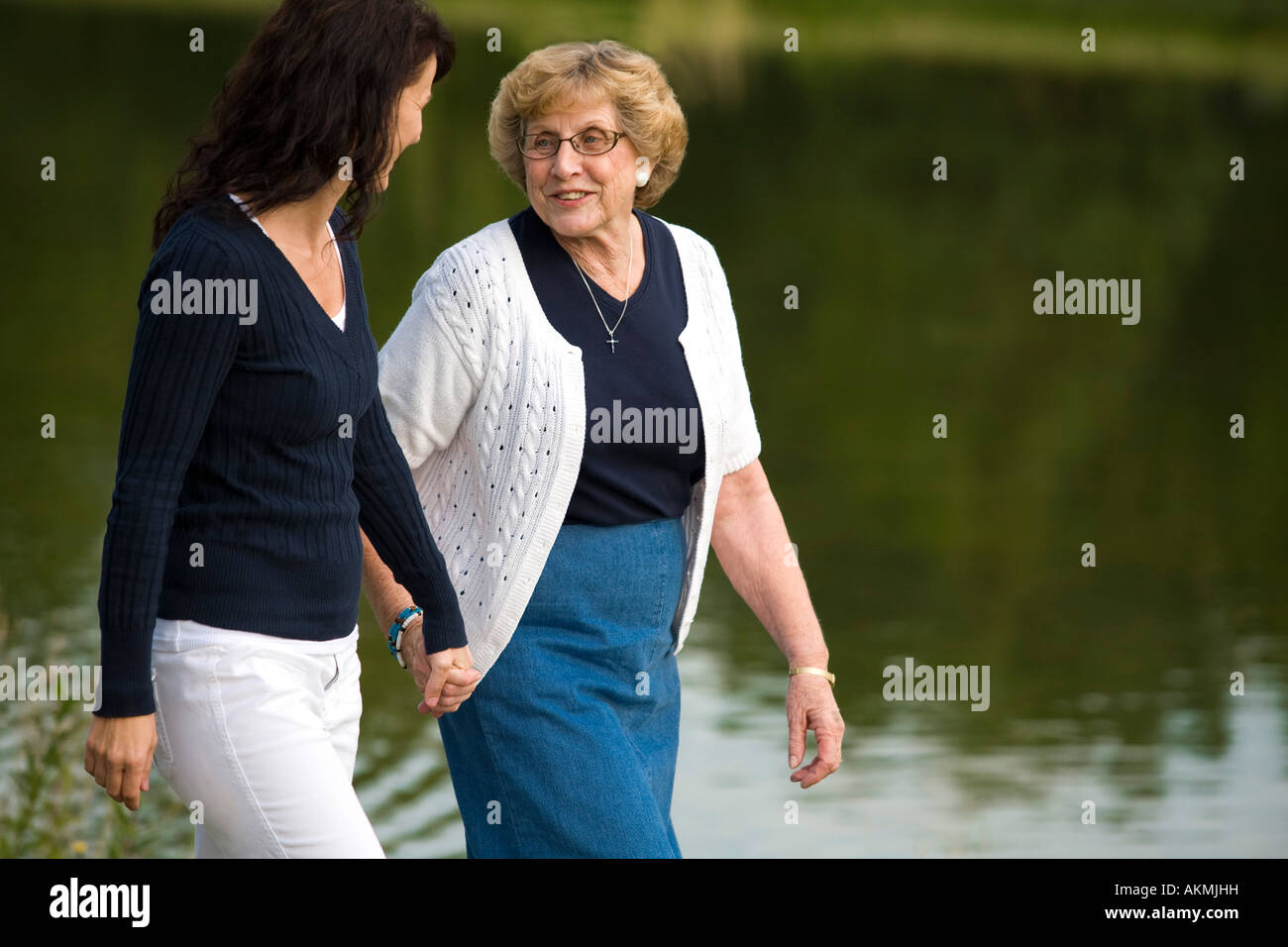 Two women walking beside a lake Stock Photo
