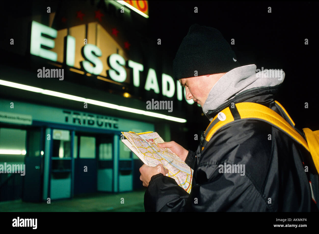 Germany Free time A young man in front of an ice stadium he is looking at a map  Stock Photo