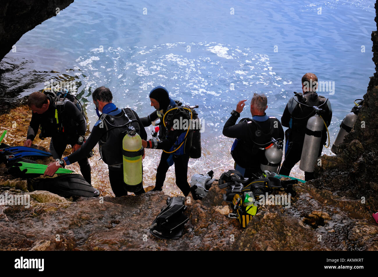 Group of divers at a cavern preparing to dip into the sea water Stock Photo