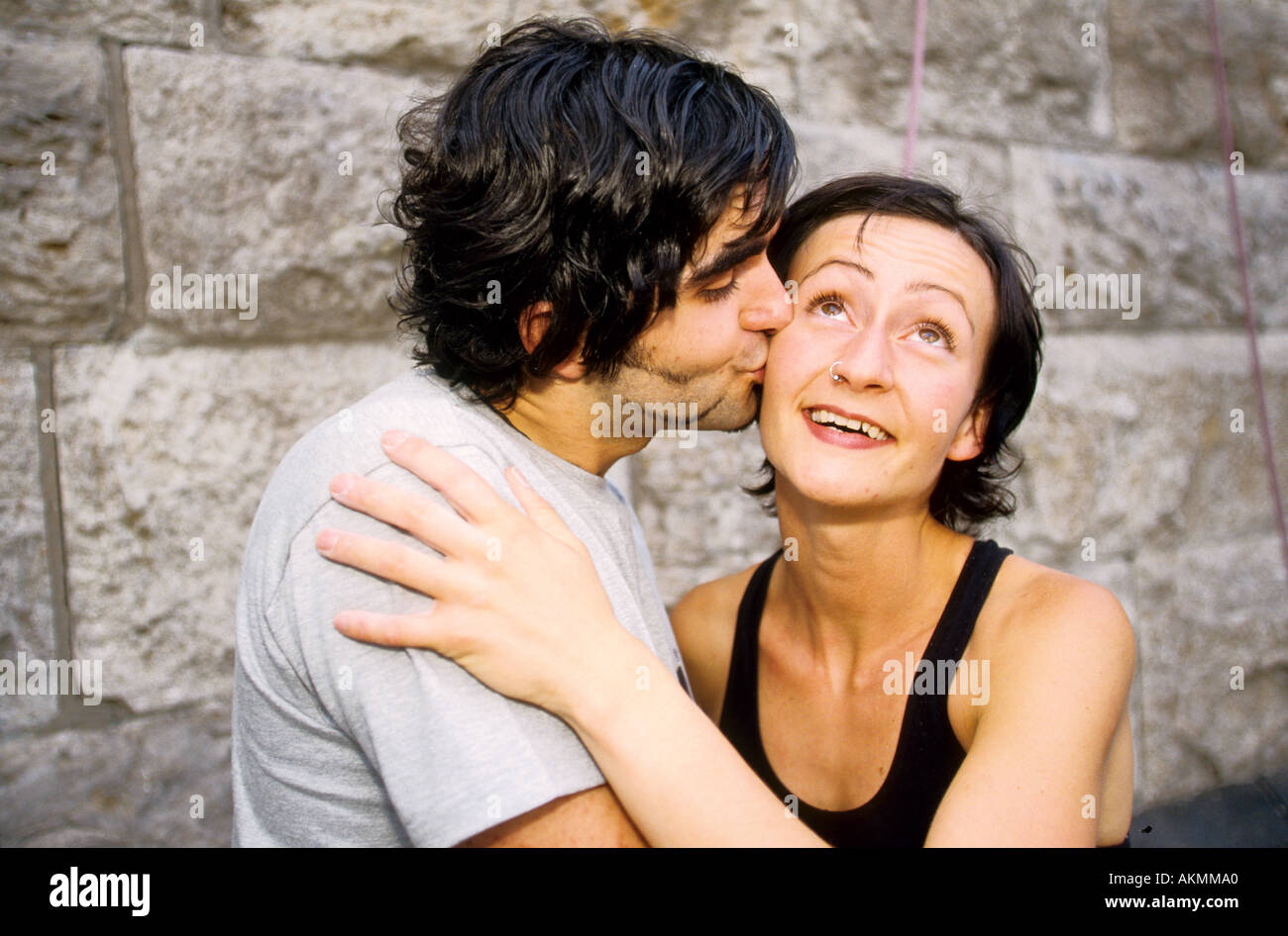 Germany Free time Young persons after climbing a man is kissing a woman on her cheek  Stock Photo