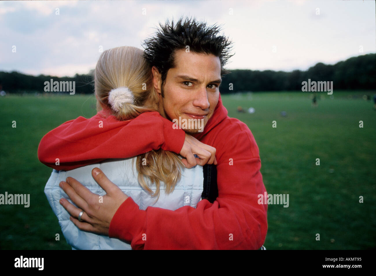 Germany Free time Two youth on a meadow they are embracing each other  Stock Photo