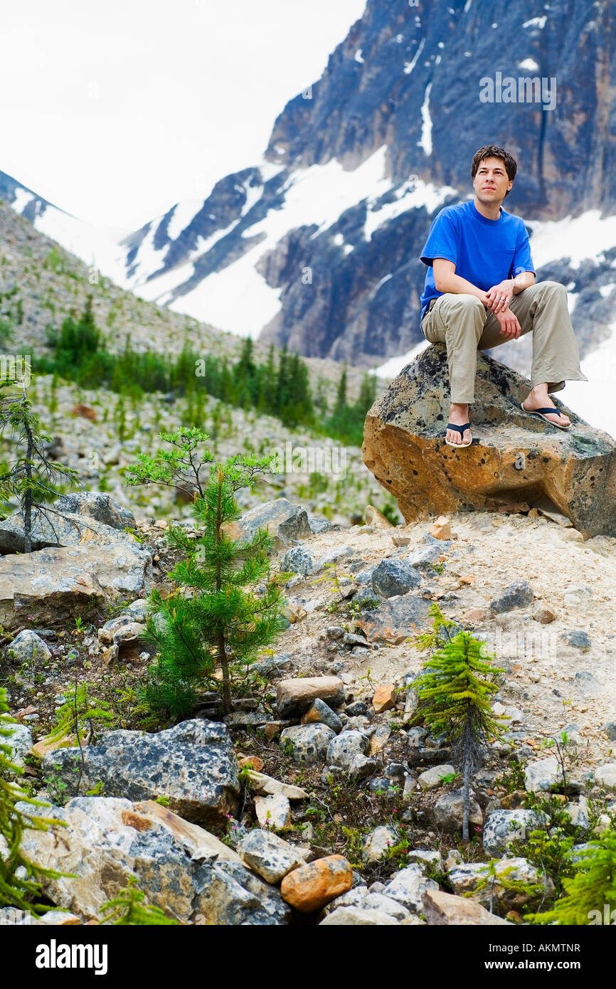 Front view of a man sitting on rock Stock Photo - Alamy