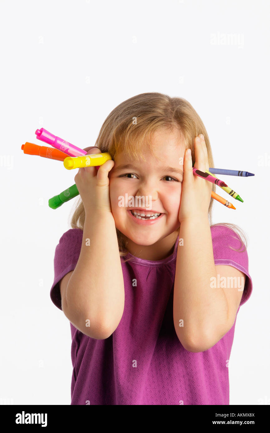 A girl holding crayons and markers Stock Photo