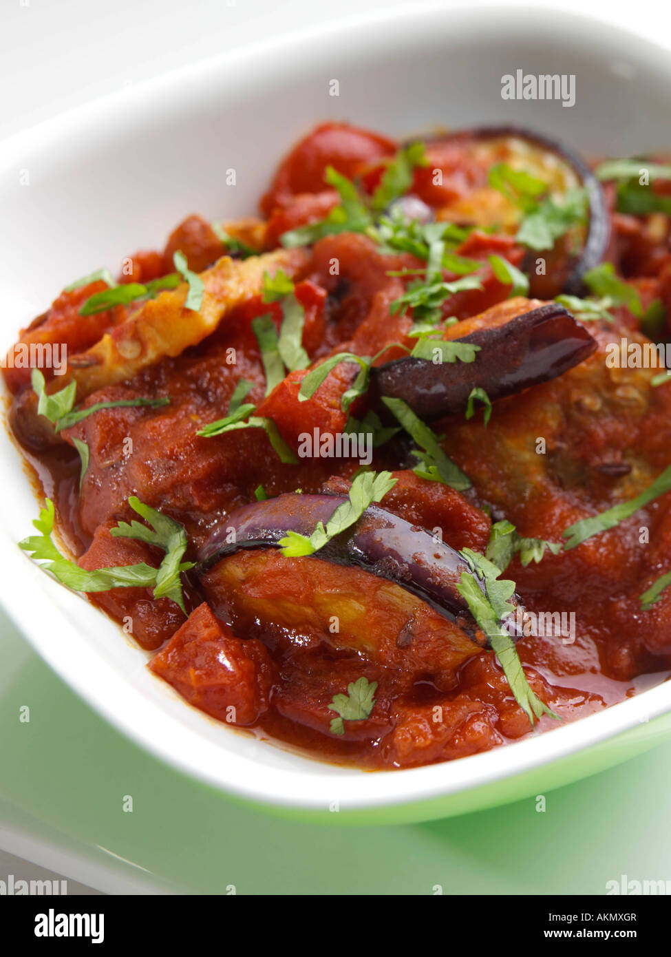 A dish of Indian tamater bagan vegetarian spicy aubergines and tomatoes