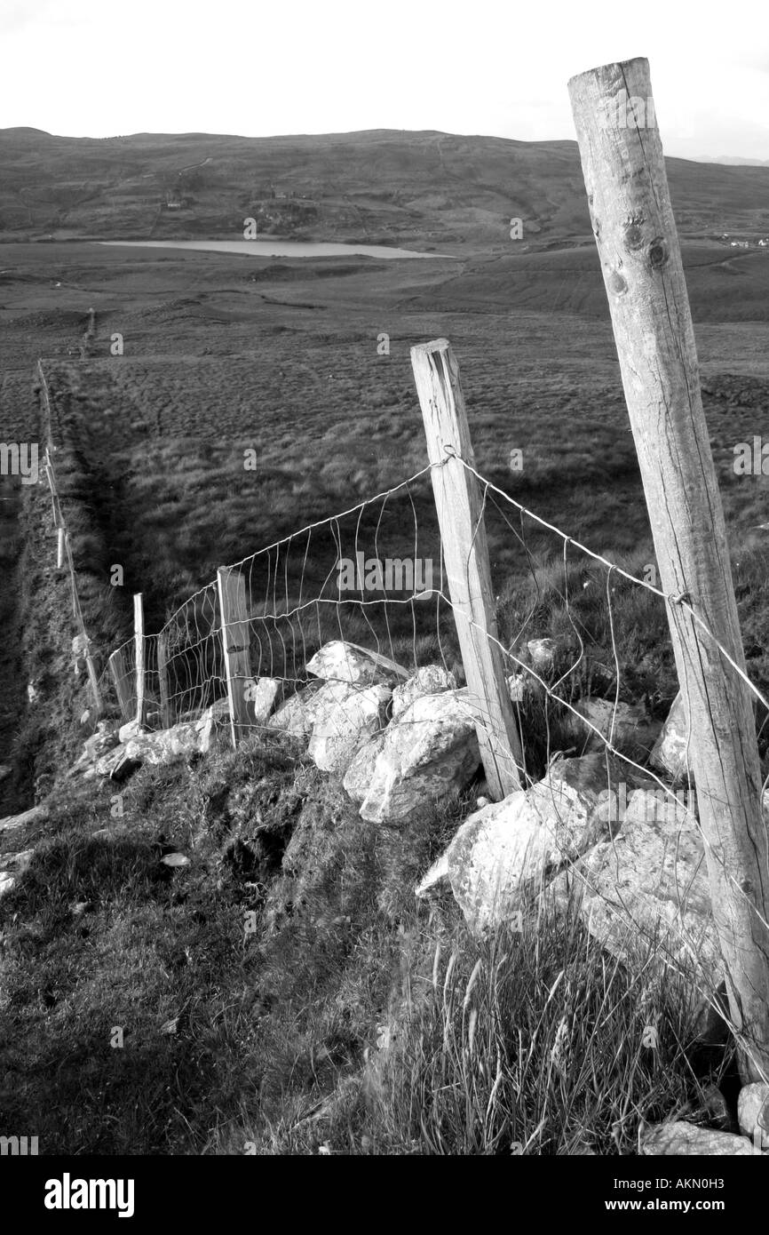 stone wall and fence running across the rolling hills of Connemara, near Clifden, County Galway, Republic of Ireland Stock Photo