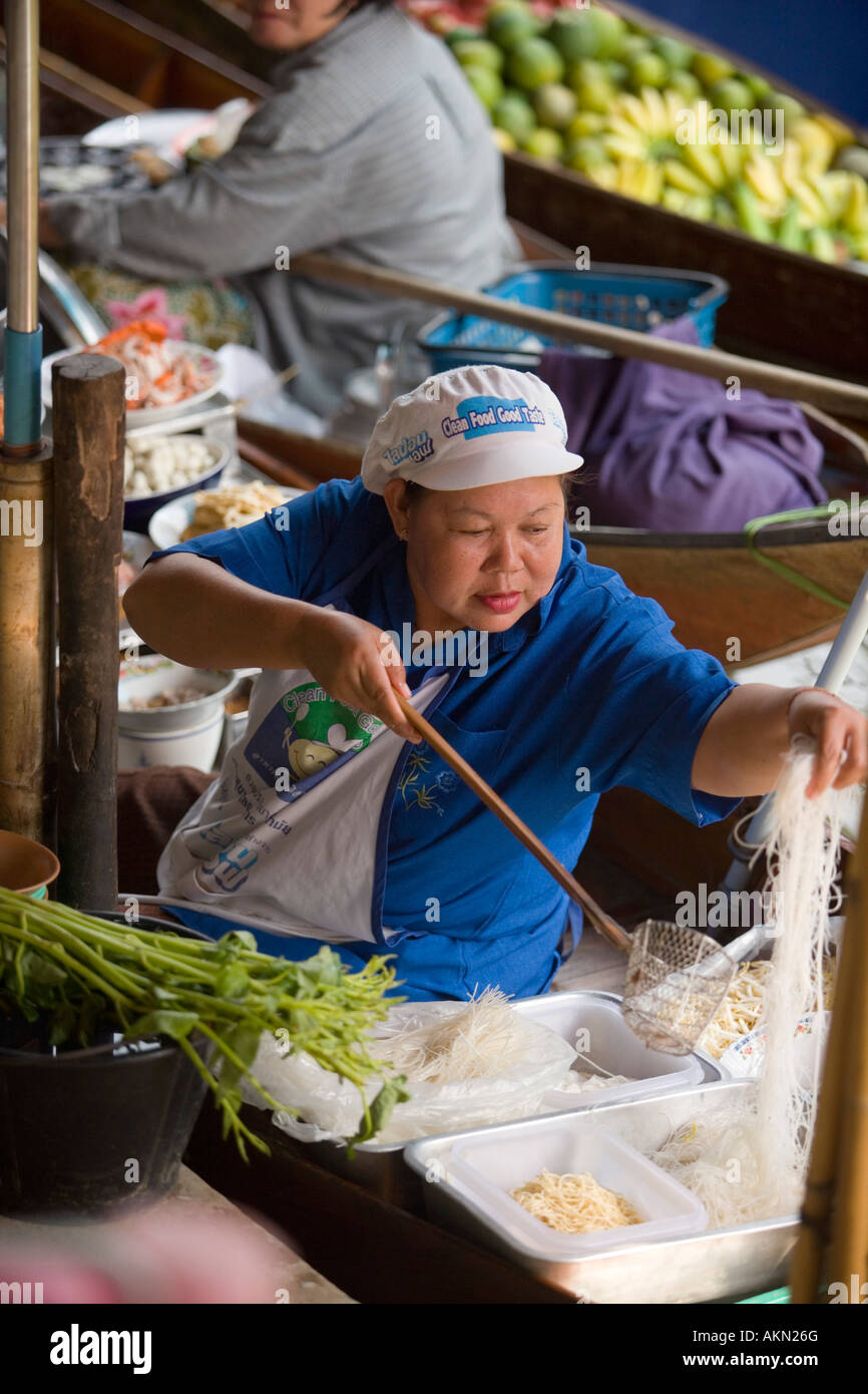 Woman cooking in a boat at Floating Market Damnoen Saduak near Bangkok Ratchaburi Thailand Stock Photo